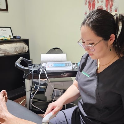 Claire Shen, kinesiologist at First Markham checking a patient's leg