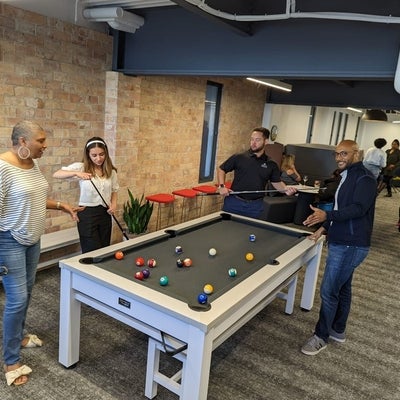 Argus co-op students and employees playing pool at the office