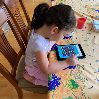 Female child playing Immunize Canada's interactive web game CARD™ at a kitchen table.