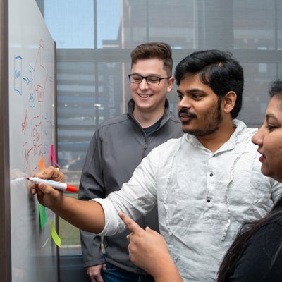 Group of co-op students at Rocket Innovation writing on a white board