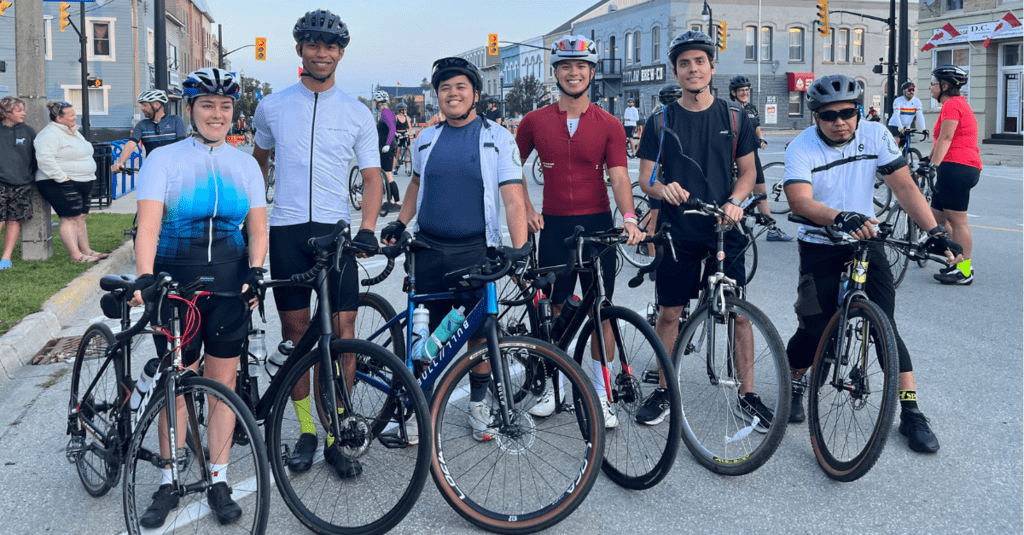 NPX team poses together standing on bikes