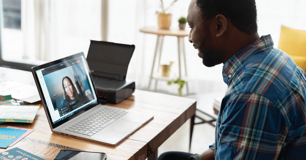 Male on a virtual work meeting on his laptop