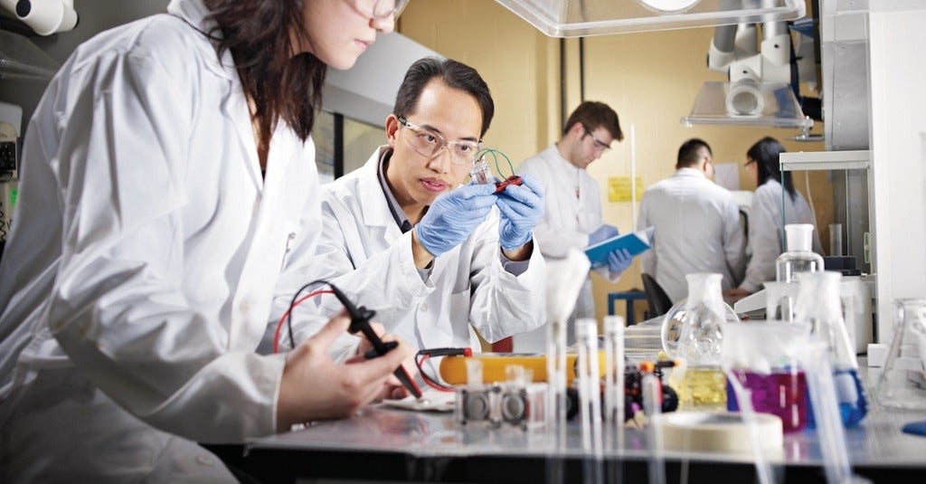 Chemical engineering student in a lab looking at circuitry