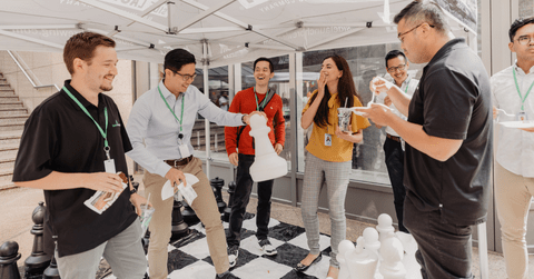 Employees and co-op students at Questrade playing a life size version of chess