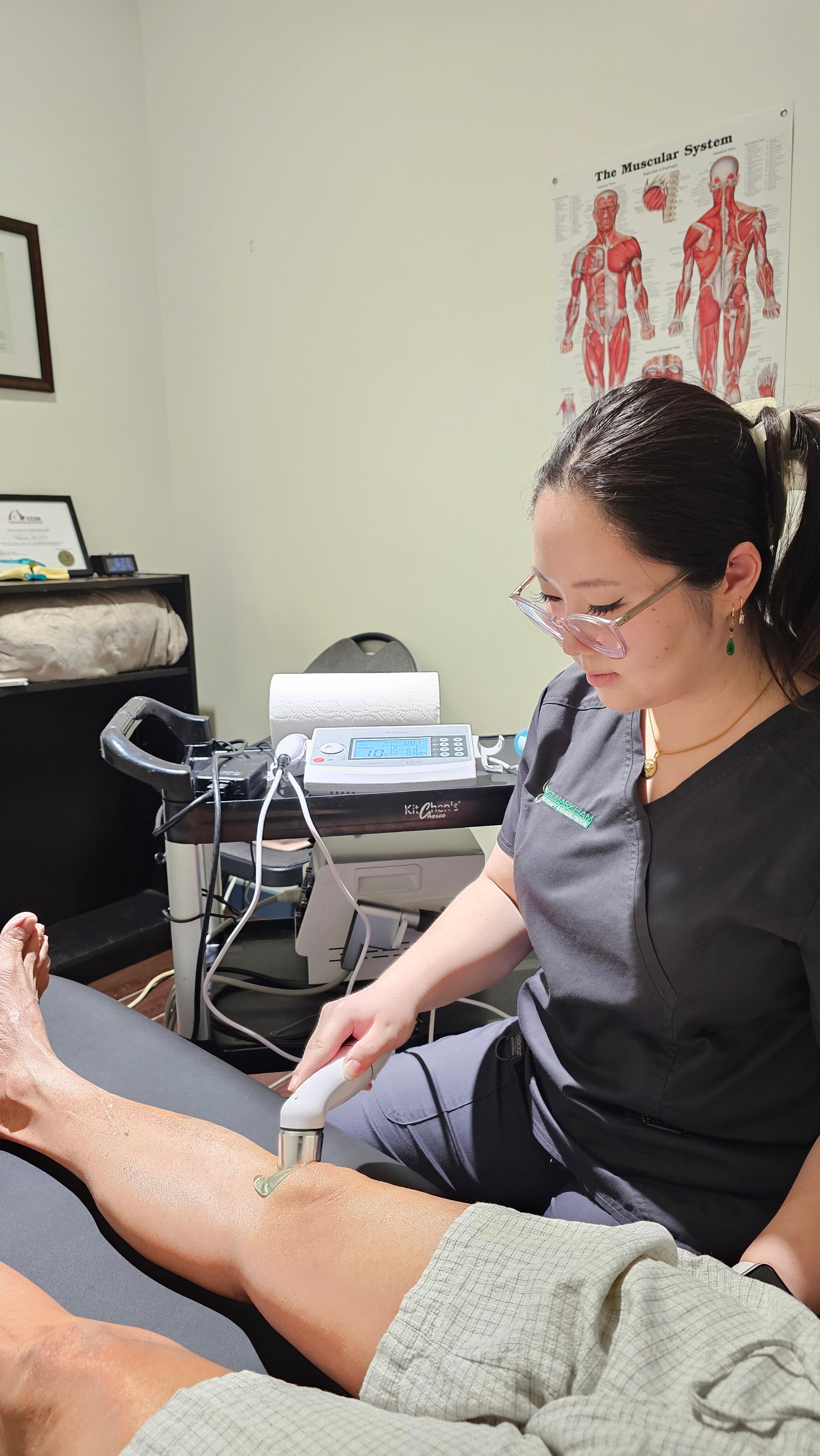 Claire Shen, kinesiologist at First Markham checking a patient's leg