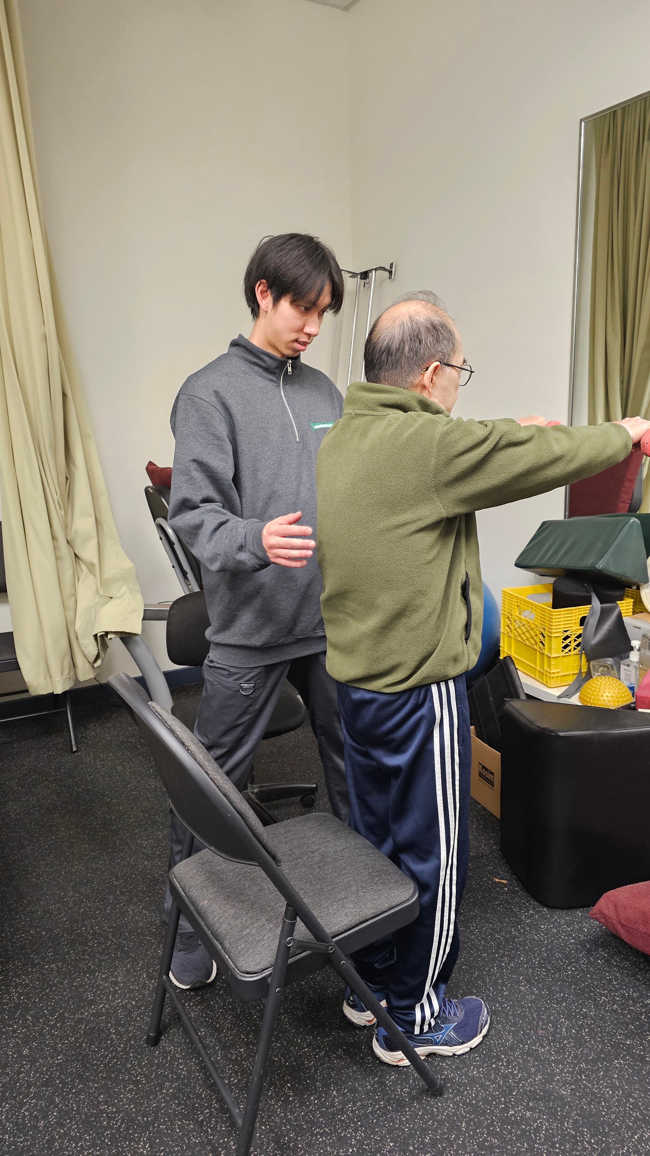 Christopher Wong, Physiotherapist at First Markham guiding an elderly patient to exercise