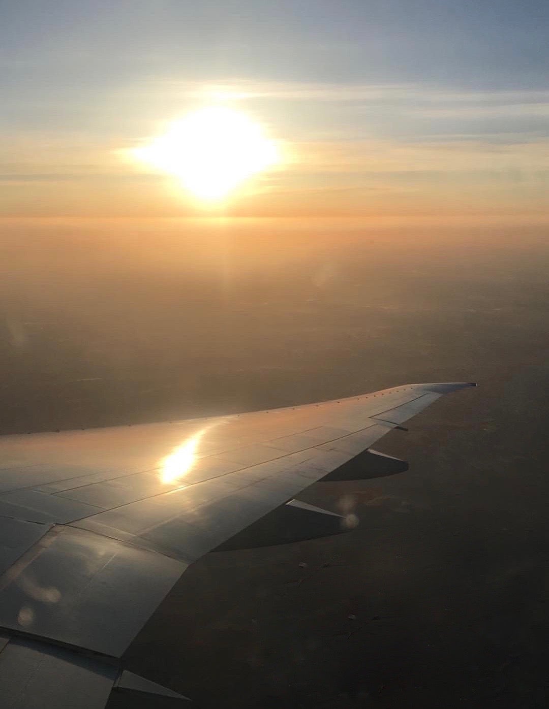 Airplane wing underneath the sunrise