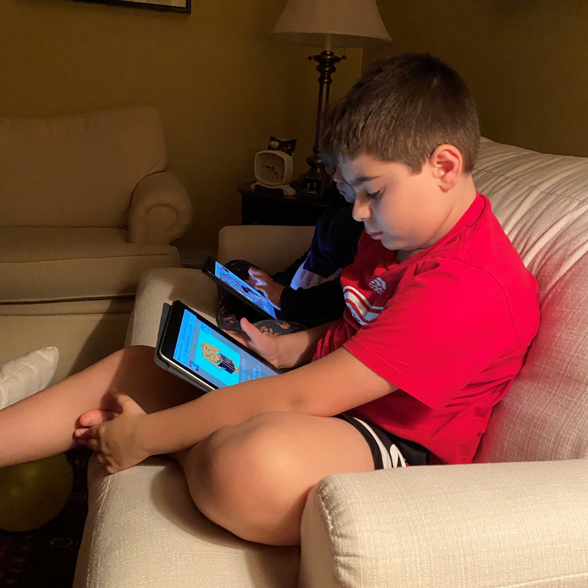 Male child playing Immunize Canada's interactive web game CARD™ while sitting on a couch.
