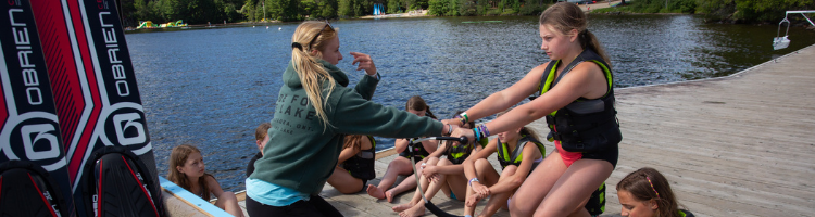 University of Waterloo co-op student demonstrating how to wakeboard to campers at Muskoka Woods