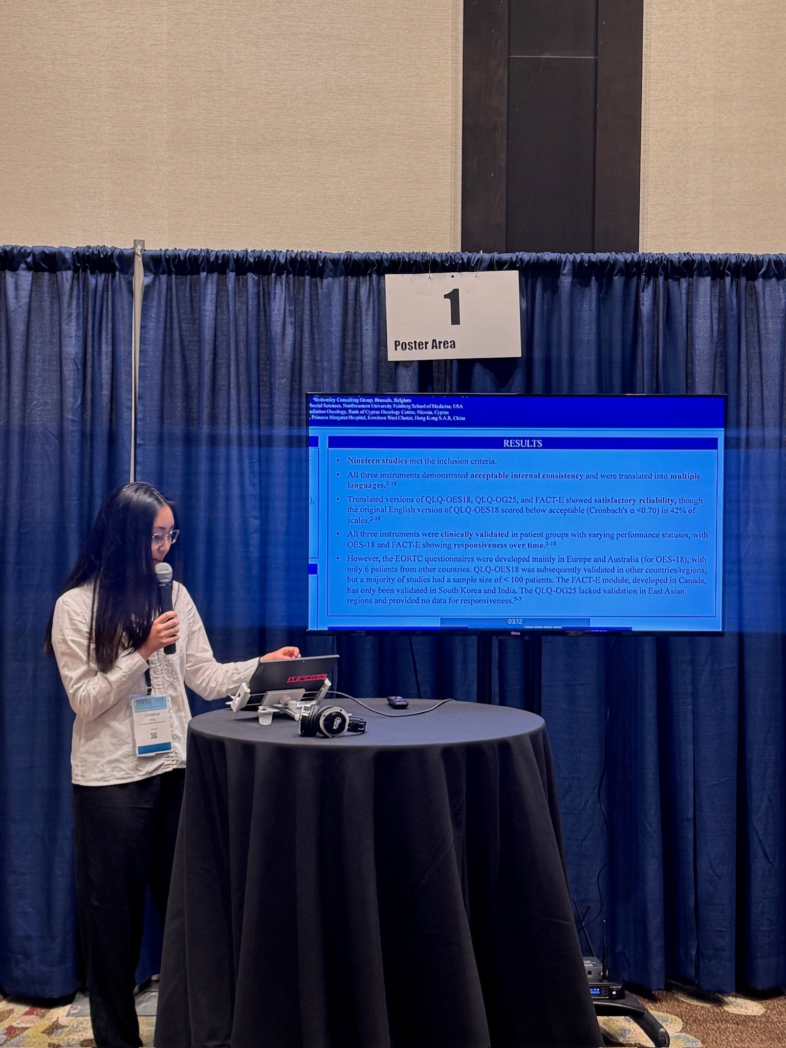 Co-op student Christina Yang holds a microphone looking at her screen as she presents a powerpoint deck.