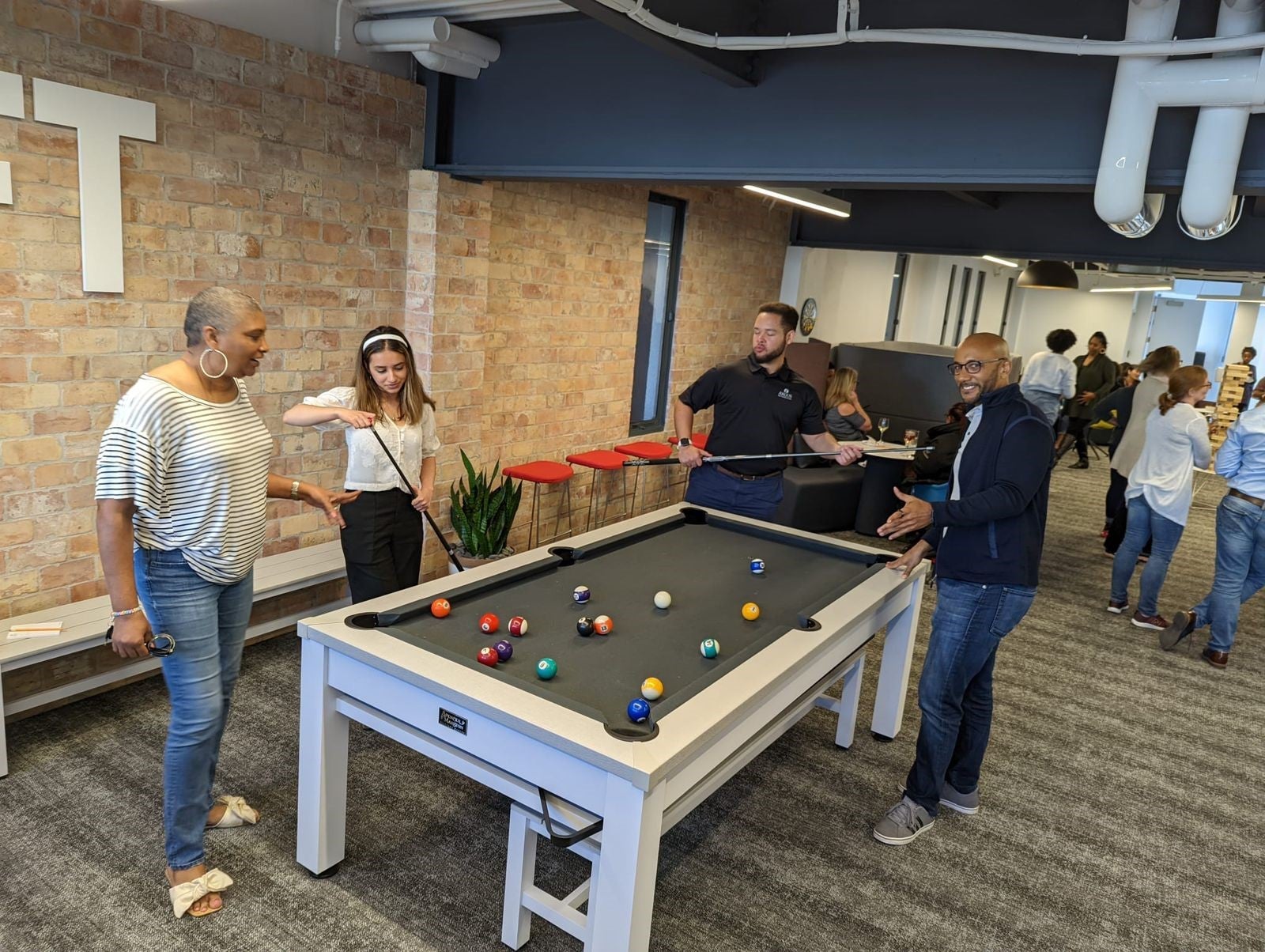 Argus co-op students and employees playing pool at the office
