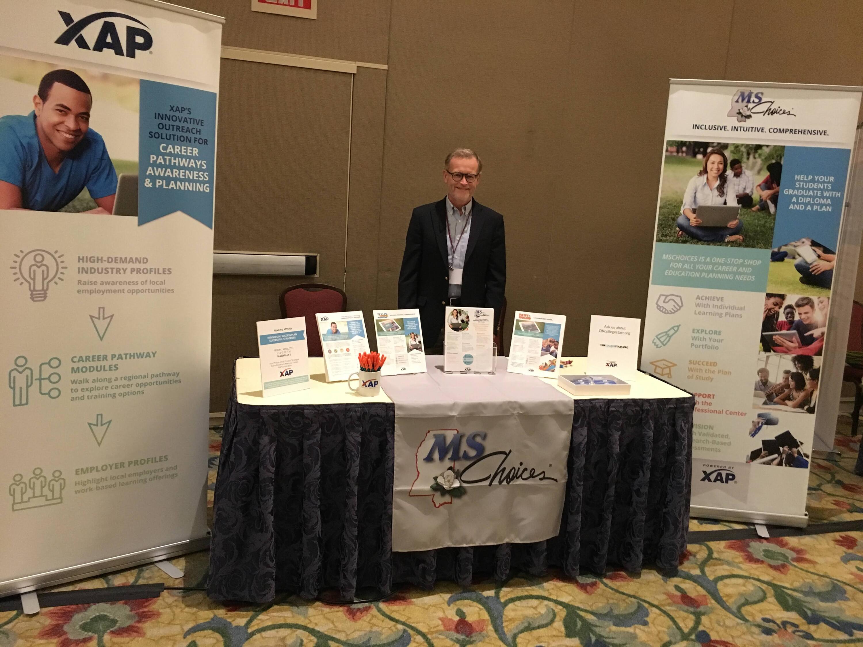 Don Phillips standing behind a booth for XAP Corporation