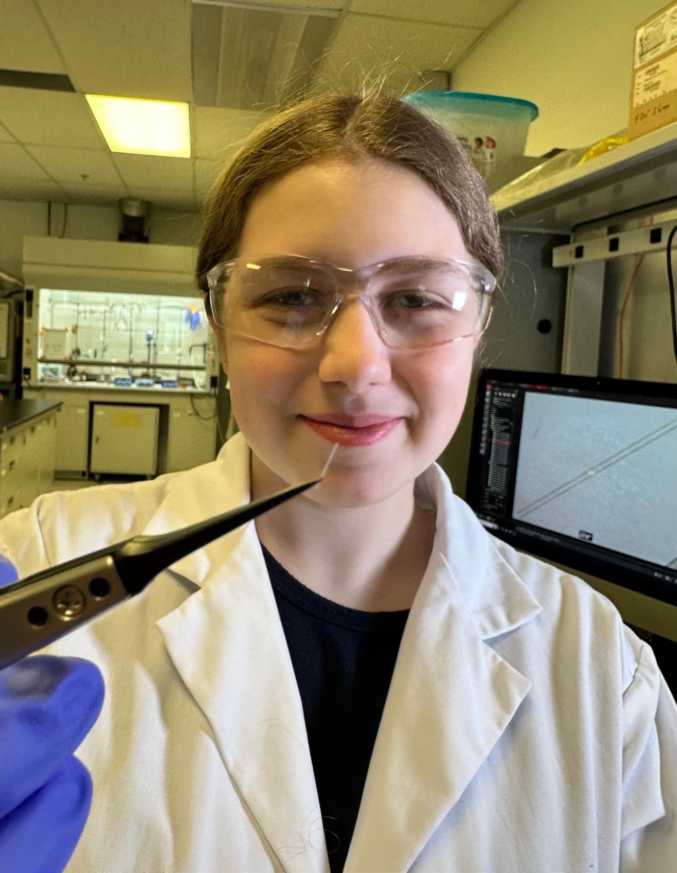Female Waterloo co-op student smiling holding something while on work term at Ripple Therapeutics