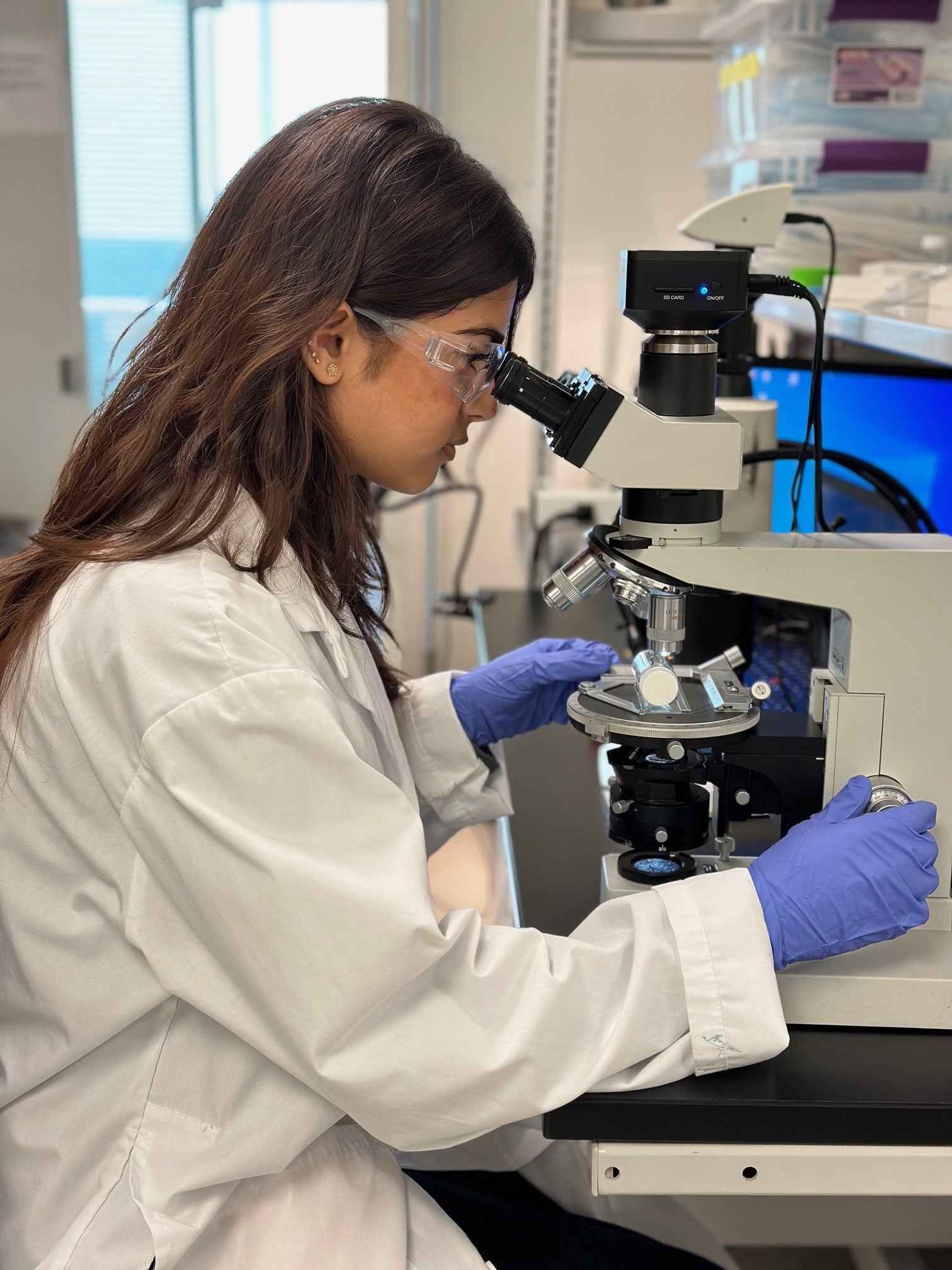 Waterloo co-op student looking into a microscope