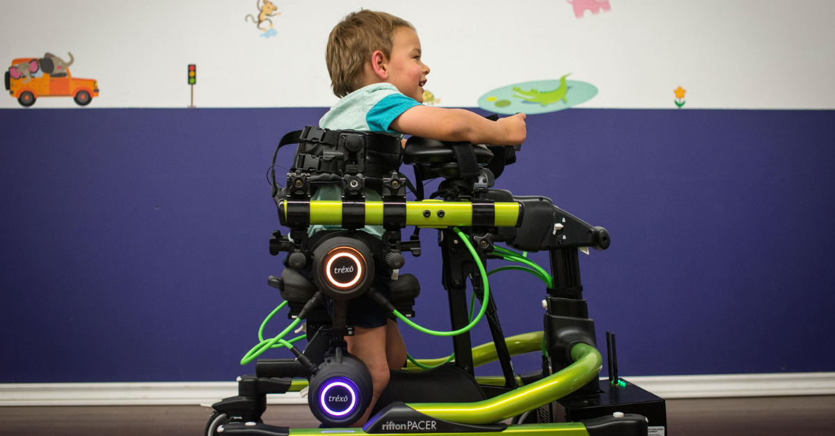 A young child using Trexo Robotics' robot Trexo, that helps people with mobility limitations walk.
