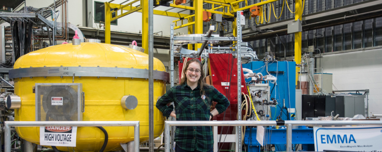 student standing in an engineering lab at TRIUMF