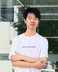 Man standing in front of building with arms crossed