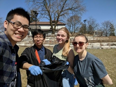 Leicester, Jean, Victoria, and Sara posing with a trash bag