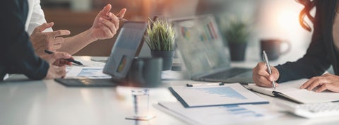 individuals working at on both sides of a communal table 