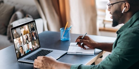 A Employee working remotely in a team meeting using their laptop