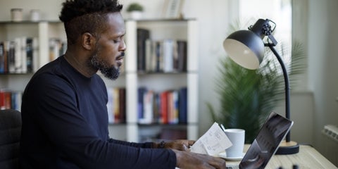 Employee looking at documents while on his laptop