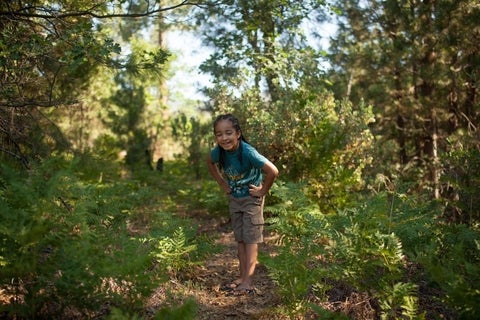 A child smiling in a forest