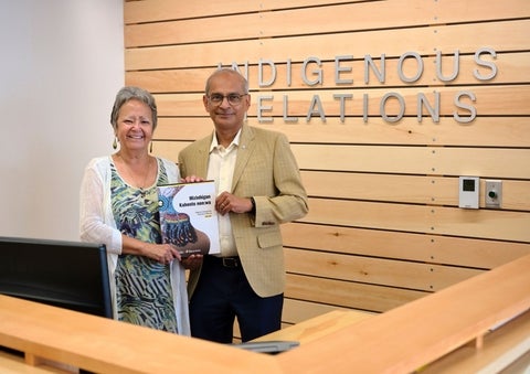 Jean Becker and Vivek Goel holding a printed copy of the Office of Indigenous Relations 5-year strategic plan