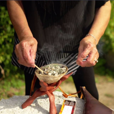 Jean Becker performing a smudging ceremony outdoors