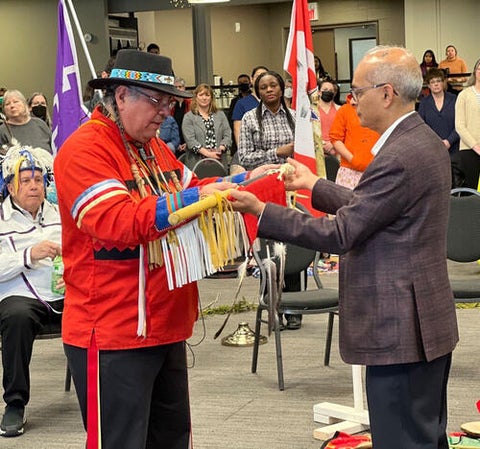 Vivek Goel and Myeengun Henry passing an Eagle Staff