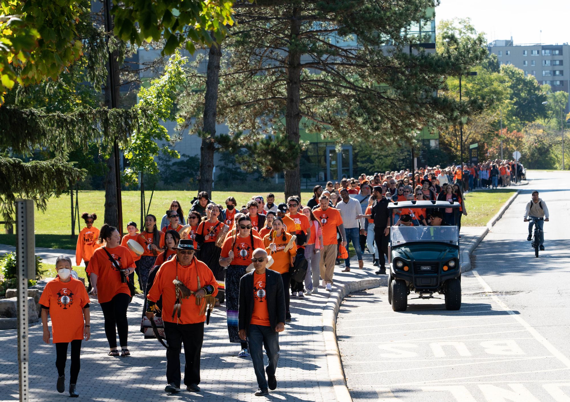 Members of the campus community wearing orange and walking Ring Road to honour National Day for Truth and Reconciliation