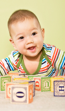 Smiling baby with blocks