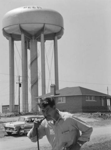 Historical photo of person drinking from the beer tower