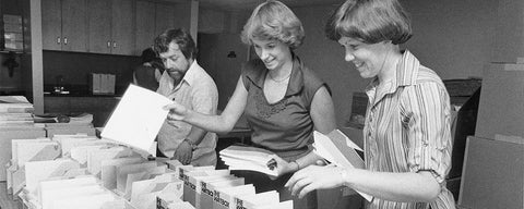 Two women and a man preparing Watboxes for high schools 