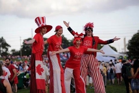 People dressed in Canadian flags on stilts