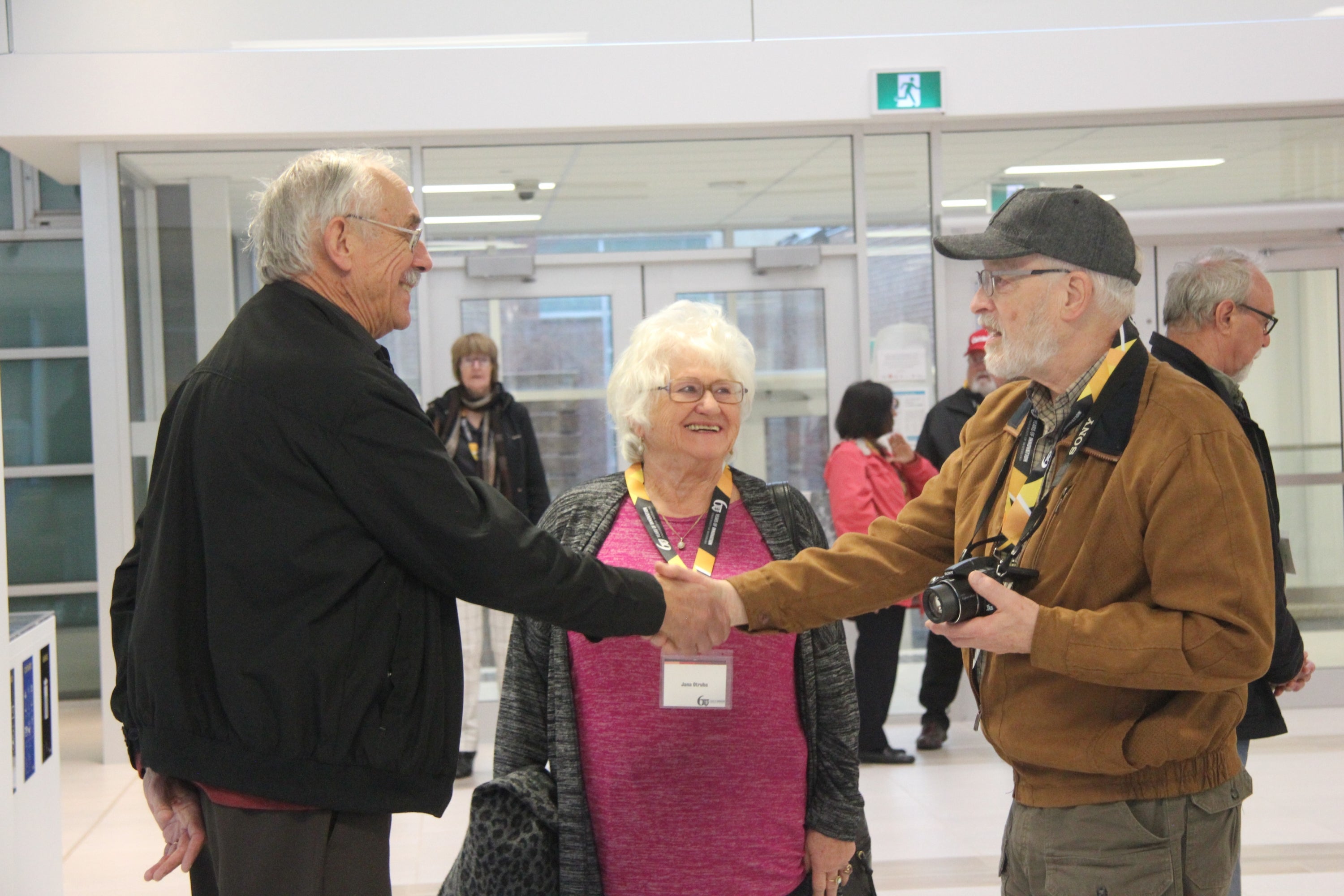 retirees shaking hands in AHS building