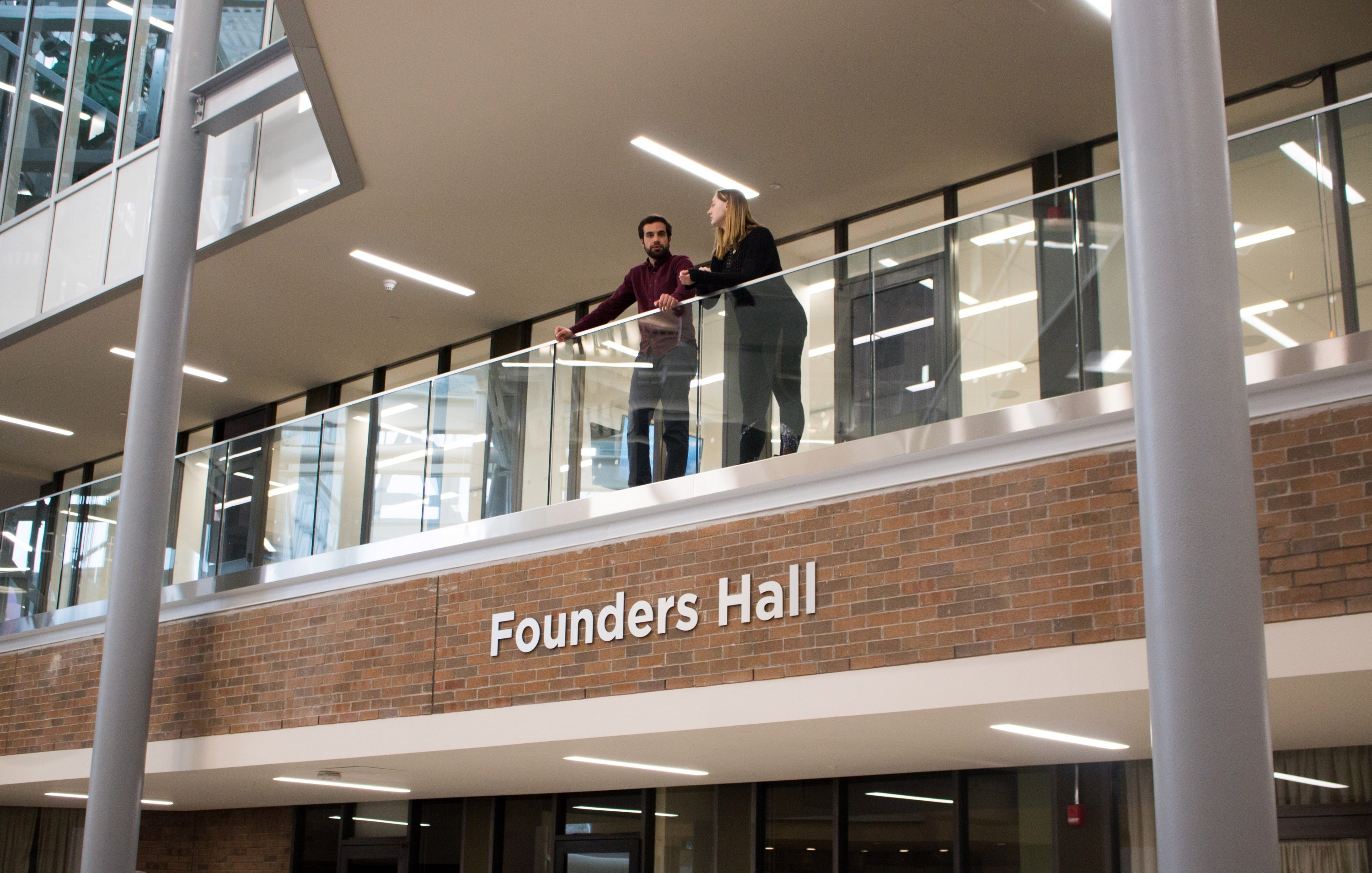 students above the Founders Hall sign in Hagey Hub
