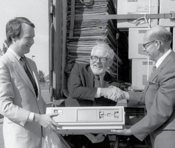 President Douglas Wright helps unpack a truckload of computer equipment