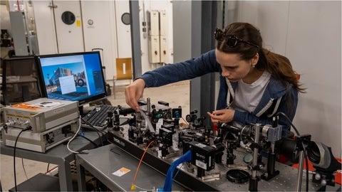 Alex Maierean adjusting a component on a laser table