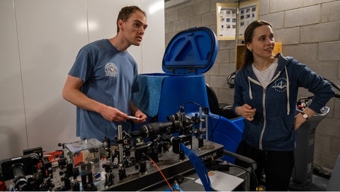 Alex Maierean and Luke Neal standing beside their laser table