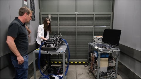 Alex Maierean in an elevator with two laser set ups on carts