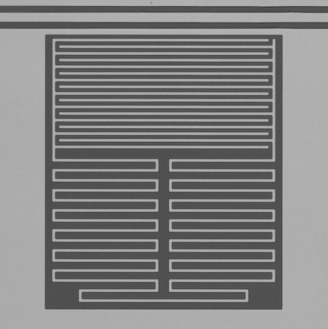 Circuit électrique résonnant supraconducteur en aluminium; les systèmes à deux niveaux sont des défauts possiblement situés à la surface de la couche d’aluminium (blanc) et du silicium exposé (gris).