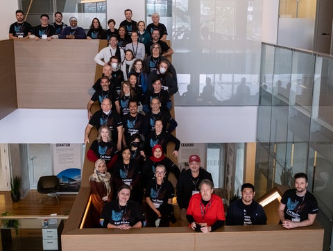A group of high school teachers posing for a photo on a staircase at IQC during the Schrodinger’s Class workshop.