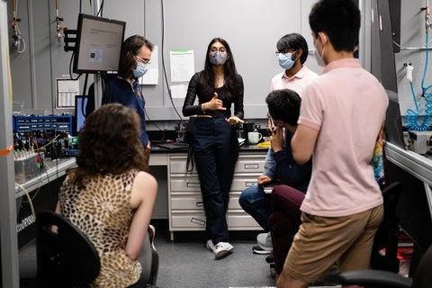 Mahadevan Subramanian and fellow USEQIP students gathered in a lab and listening to a presenter