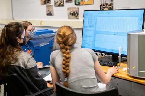 Students working on a nuclear magnetic resonance spectrometer.