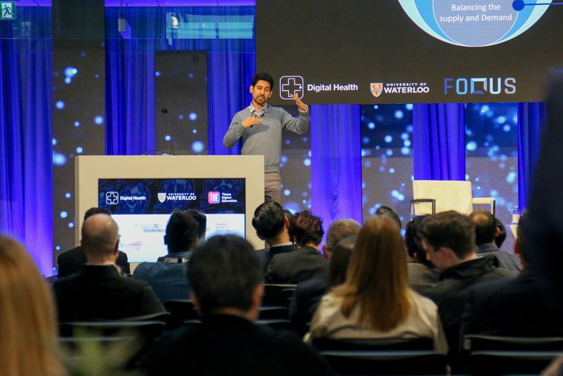 Foqus founder and CEO Sadegh Raeisi speaks on stage to an audience.