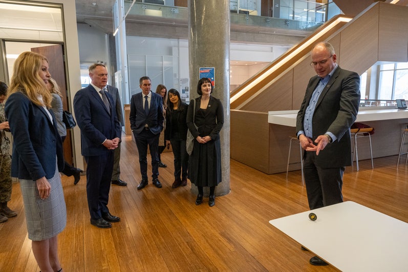 IQC's Norbert Lutkenhaus displays item that represents quantum mechanics to group 