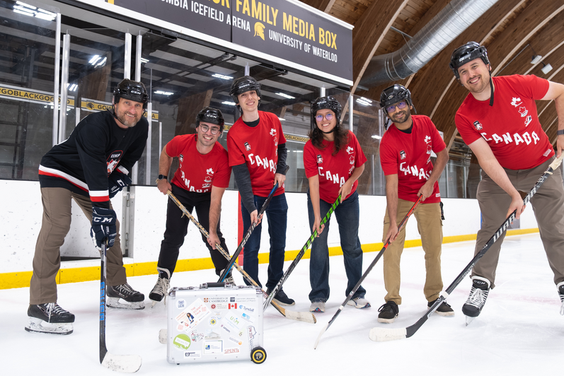 A group of six researchers from Quantum Photonic Devices Laboratory wearing hockey gear on Waterloo's ice rink