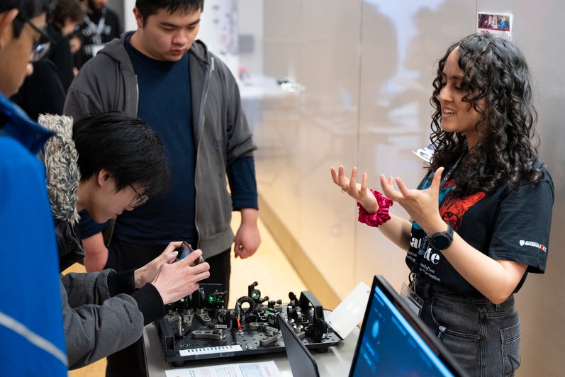 Outreach employee explains quantum science to onlookers
