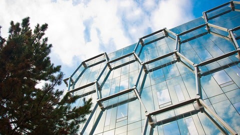 The Quantum Nano Centre against a cloudy sky backdrop