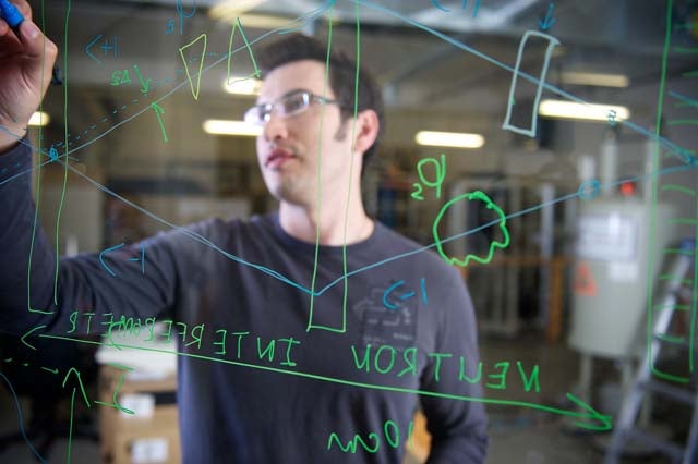  IQC researcher Dmitry Pushin sketches a neutron interferometer similar to the one developed with NIST